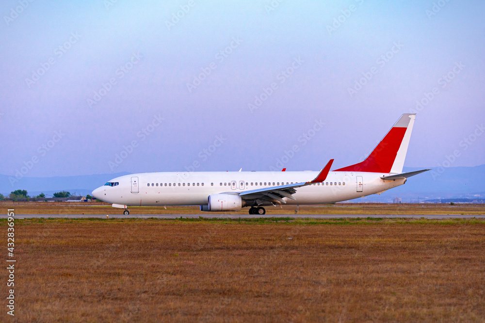 Big passenger airplane drives along the runway in airport