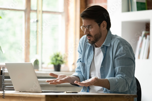 Konstfotografi Unhappy irritated businessman in glasses looking at laptop screen, reading bad n