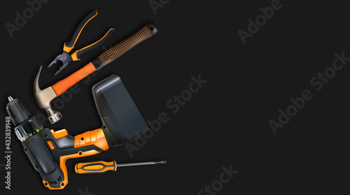 Orange tools professional realistic on black background. Hammer, cordless drill, screwdriver and pliers. 3d composition for labor day. Copy-space.