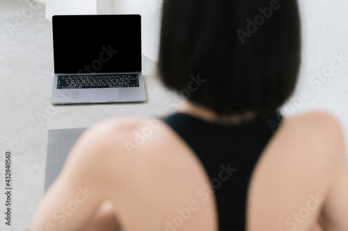 Asian young sporty slim woman coach internet video online training oga instructor modern laptop screen meditate relax breathe easy seat pose gym healthy lifestyle concept.