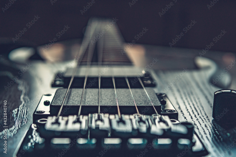 Closeup of wooden electric guitar with six strings, selective focus on strings Closeup of wooden electric guitar with six strings, selective focus on strings