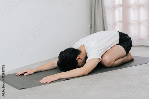 Asian young man doing yoga at home