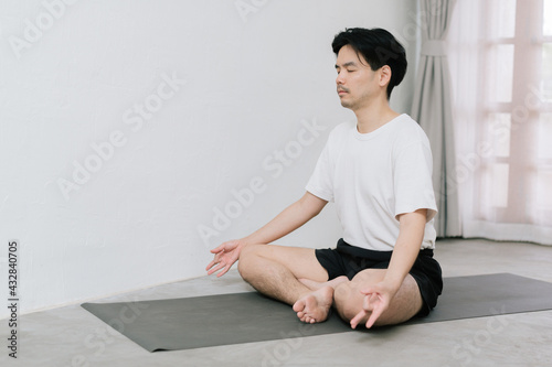 Asian young man doing yoga at home