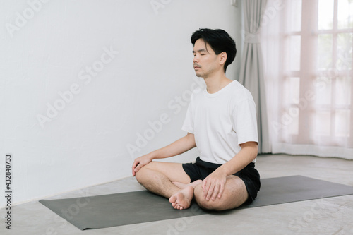 Asian young man doing yoga at home