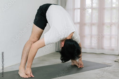 Asian young man doing yoga at home