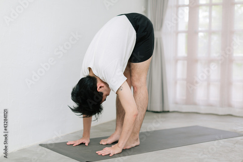 Asian young man doing yoga at home