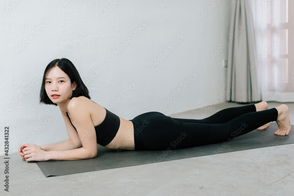 Young asian woman doing sport exercises indoor at home Young asian woman doing sport exercises indoor at home