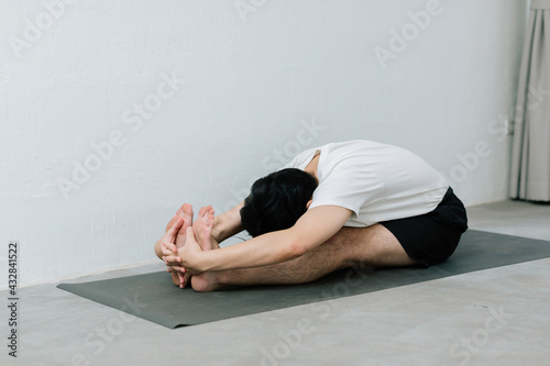 Asian young man doing yoga at home