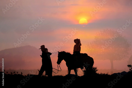The silhouette of the cowboy and the setting sun © subinpumsom