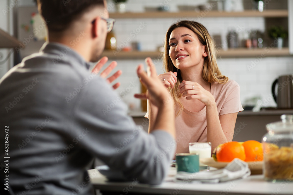 Beautiful young girl enjoying in breakfast with her boyfriend. Loving couple drinking coffee in the kitchen.. Beautiful young girl enjoying in breakfast with her boyfriend. Loving couple drinking coffee in the kitchen..