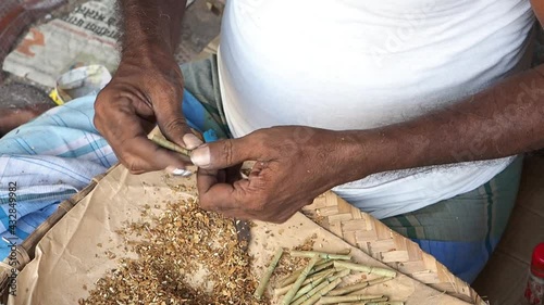 A closeup of an Indian man making beedi outdoors shot in HD photo