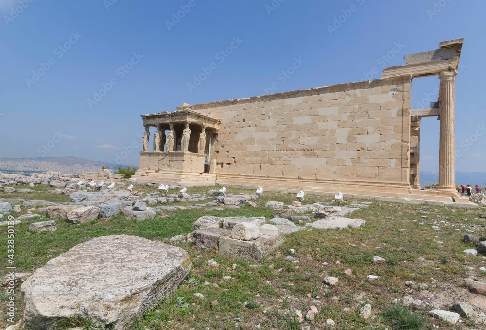 The ancient Erechtheion temple with beautiful Caryatids on Acropolis hill, famous tourist attraction in Athens, Greece, in sunny summer day