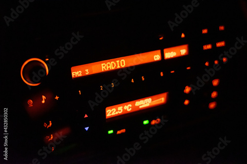Modern car radio illuminated with orange color