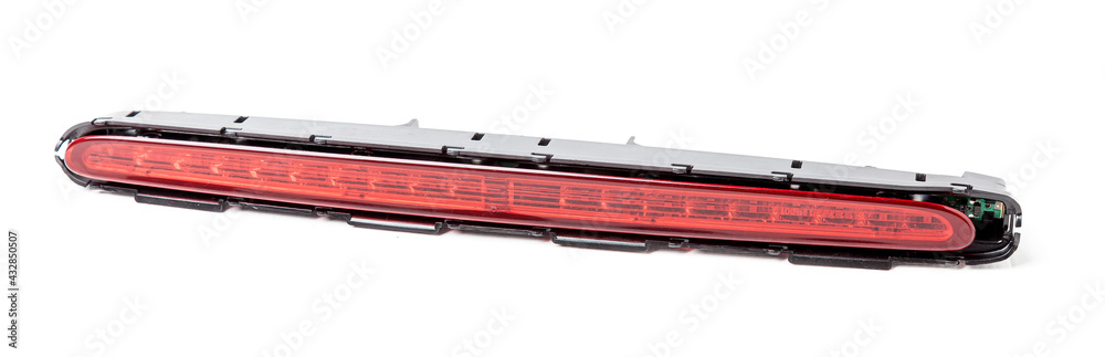 Spare part for sale at an auto-parsing or repair of a car body in service on a white isolated background in a photo studio - LED additional brake light from black and red plastic. Spare part for sale at an auto-parsing or repair of a car body in service on a white isolated background in a photo studio - LED additional brake light from black and red plastic.