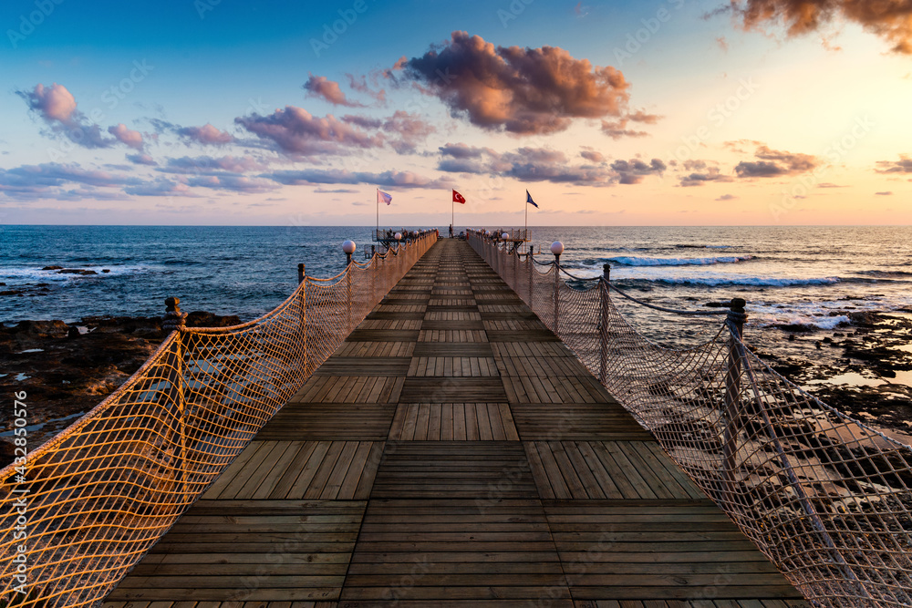 Wooden pier and sunset over sea.