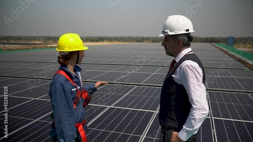 Wallpaper Mural Solar power plant engineer woman in blue uniform and hardhat talking with senior businessman installing photovoltaic on rooftop at warehouse factory . technician female checking Solar Cell  outdoors. Torontodigital.ca