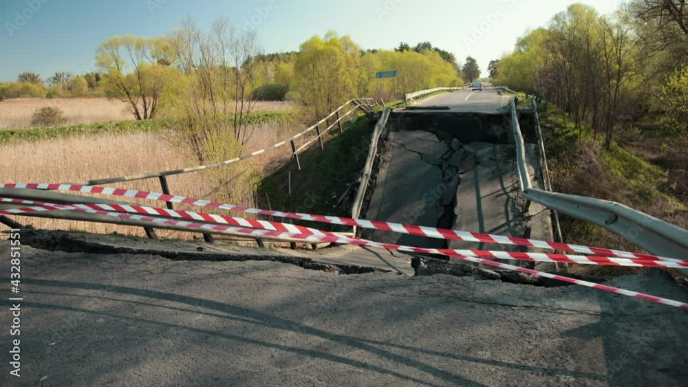 Falling parts and fittings, danger. Damaged roads on an old bridge. Broken road on the bridge. Beautiful sunny summer day. Damaged by hurricane. Falling parts and fittings, danger. Damaged roads on an old bridge. Broken road on the bridge. Beautiful sunny summer day. Damaged by hurricane.