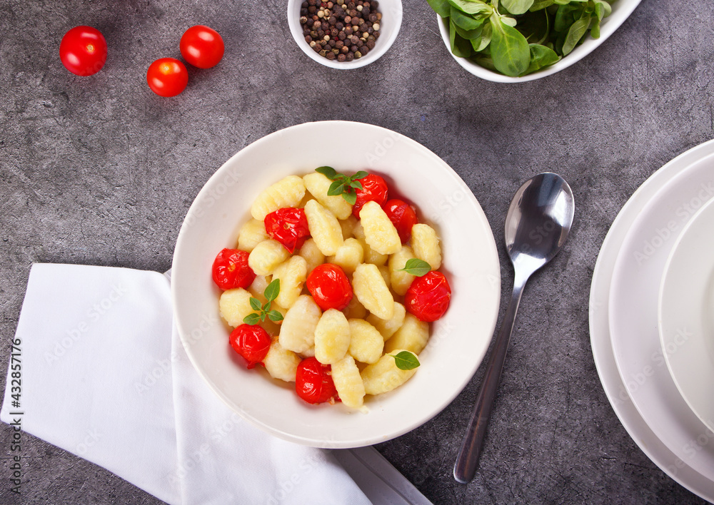 Homemade Italian gnocchi with tomato cherry on the wooden table