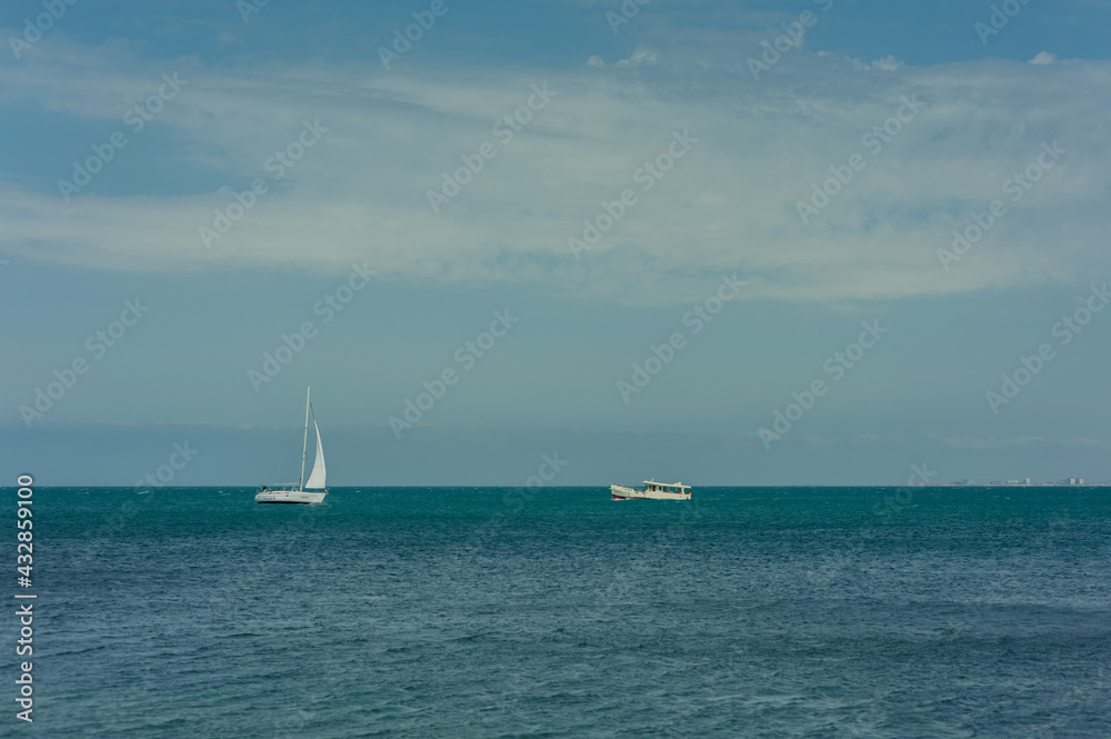 Obraz premium two small white yachts in the summer at sea in the distance