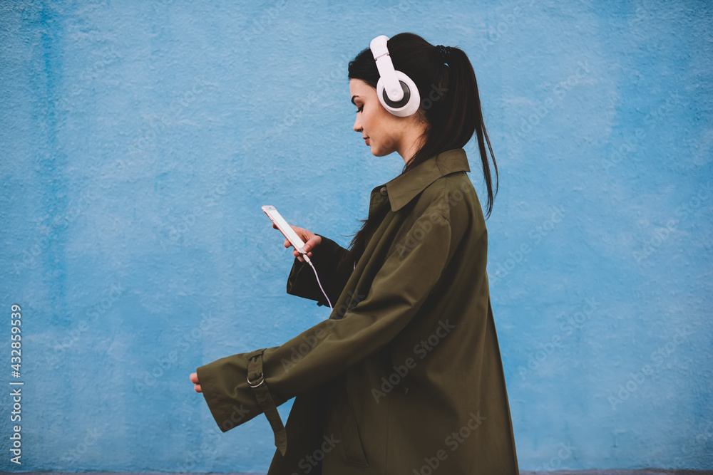 Stylish woman using smartphone and headphones