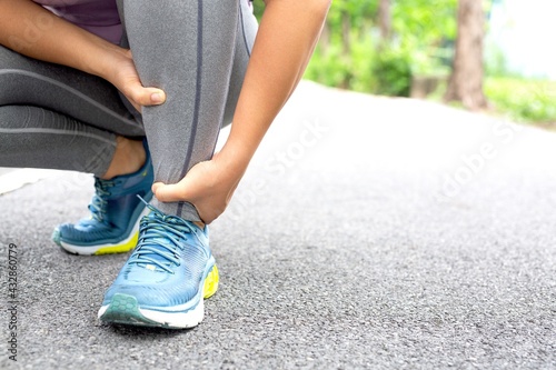 Woman runners hurt their knees from a heavy stroke at the park. © kamonwan