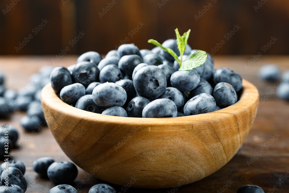 Juicy and fresh blueberries with green leaves on a rustic table. Vegan and vegetarian concept. Juicy and fresh blueberries with green leaves on a rustic table. Vegan and vegetarian concept.