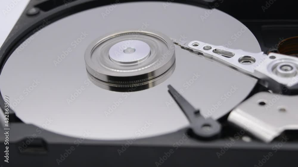 Video of Opened Hard Disk Drive with spinning platter. Close up of a hard disk drive reading and writing data. Disassembled hdd reading head. Video of Opened Hard Disk Drive with spinning platter. Close up of a hard disk drive reading and writing data. Disassembled hdd reading head.