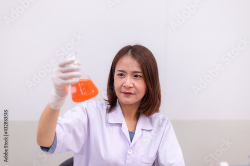 Young women researchers, doctors, scientists working with plastic medical tubes to examine scientific experiments in modern laboratories.