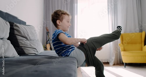 a little boy dresses in pants in the morning, prepares for the exit