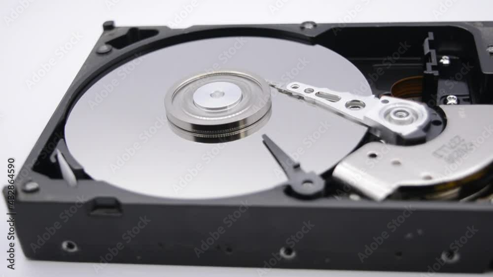 Video of Opened Hard Disk Drive with spinning platter. Close up of a hard disk drive reading and writing data. Disassembled hdd reading head. Video of Opened Hard Disk Drive with spinning platter. Close up of a hard disk drive reading and writing data. Disassembled hdd reading head.