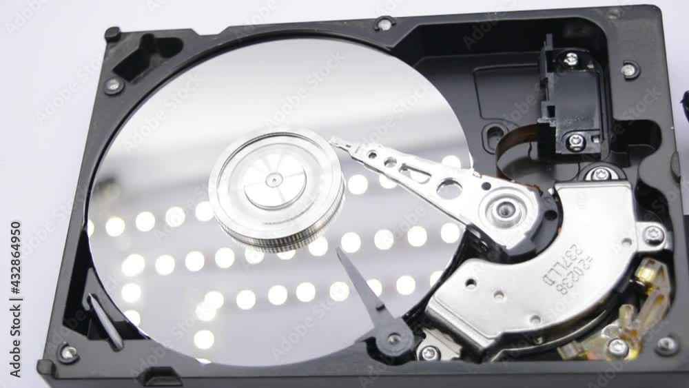 Video of Opened Hard Disk Drive with spinning platter. Close up of a hard disk drive reading and writing data. Disassembled hdd reading head. Video of Opened Hard Disk Drive with spinning platter. Close up of a hard disk drive reading and writing data. Disassembled hdd reading head.