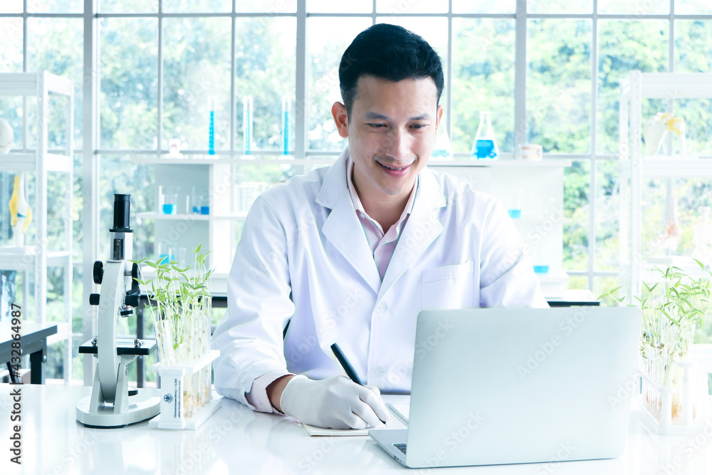 Scientists, researchers in Asia, use a laptop and record the results of the study. Or making a report in a science laboratory Scientists, researchers in Asia, use a laptop and record the results of the study. Or making a report in a science laboratory