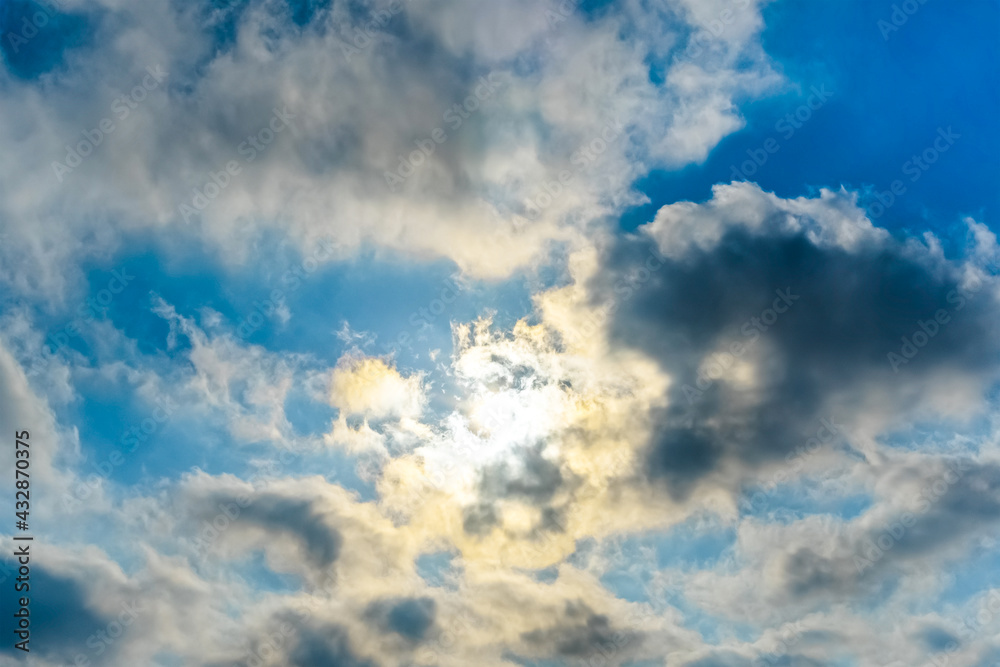 Obraz premium The rays of the sun break through the clouds.Blue sky with white feather clouds. Panoramic view of the blue sky with clouds in motion.Nice weather with clear skies. Panorama of the sky in motion