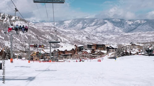 USA. Aspen. March 2021.Panoramic view on town in Colorado during winter season. People on skis and snowboards on the slopes of the ski resort. Ski elevator on snow mountain. 