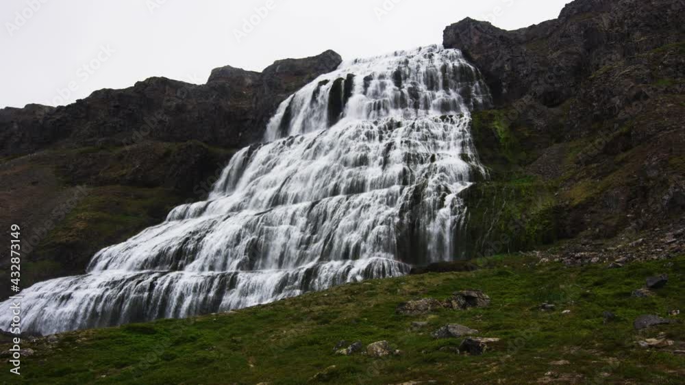 Wide and massive waterfall on tall mountain in low angle zoom in view Wide and massive waterfall on tall mountain in low angle zoom in view