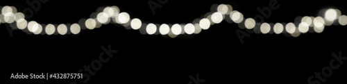 Abstract blurred light spots bokeh on festive dark background for cover page, decorate with light at night. © Stella