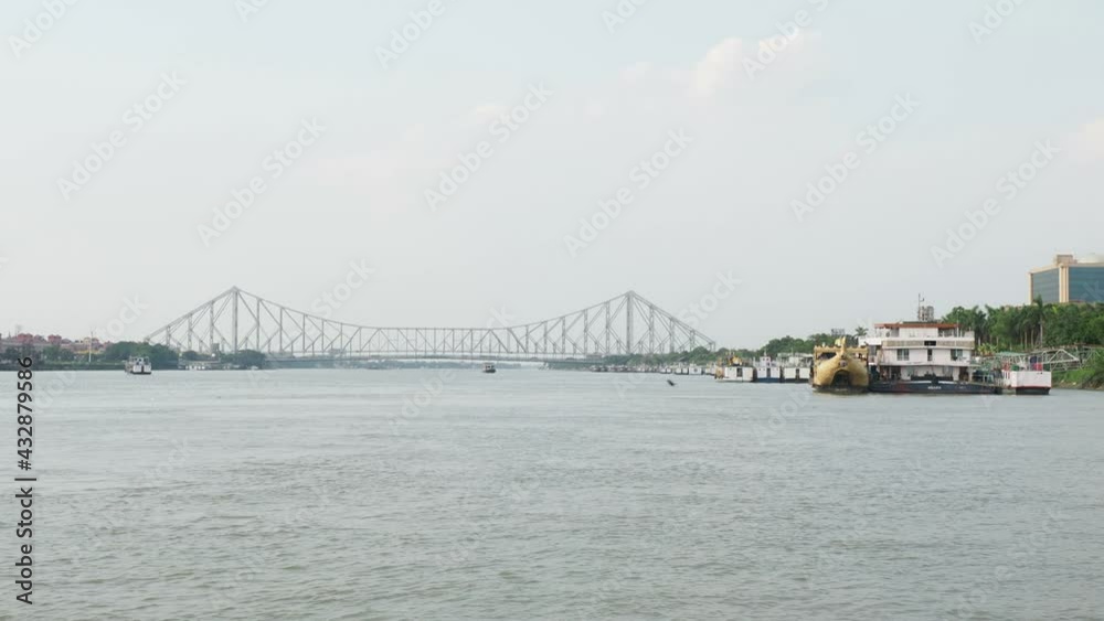 KOLKATA, INDIA - May 01, 2021: View of Howrah bridge from ferry boat service which runs in Ganges river. Beautiful Kolkata city.