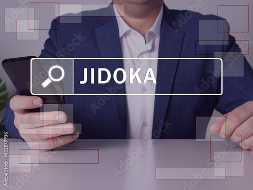  JIDOKA text in search line. Manager looking for something at smartphone. JIDOKA concept. photo