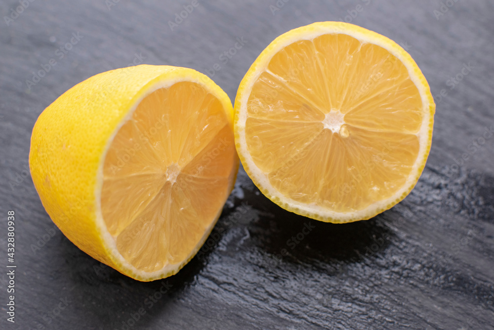 Juicy fresh lemon on a black stone background. Gastronomic concept. Juicy fresh lemon on a black stone background. Gastronomic concept.