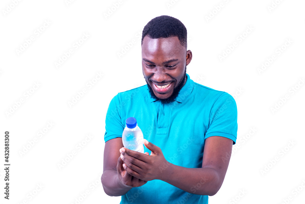 handsome young man looking at bottle of mineral water smiling. handsome young man looking at bottle of mineral water smiling.