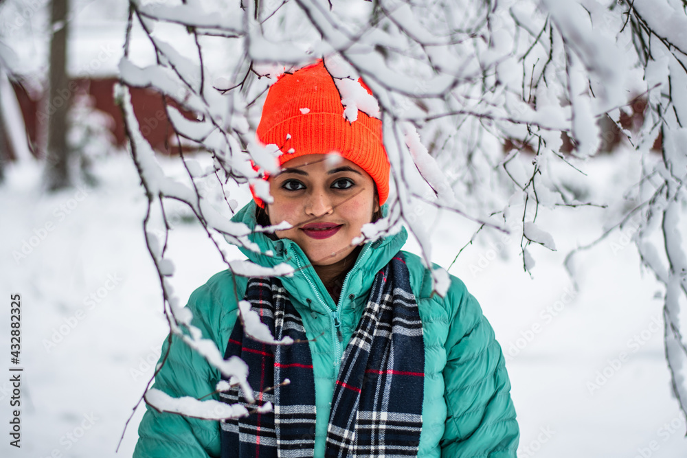 A pretty young woman in a winter landscape enjoying the snow fashion photoshoot behind the snow covered tree branches A pretty young woman in a winter landscape enjoying the snow fashion photoshoot behind the snow covered tree branches