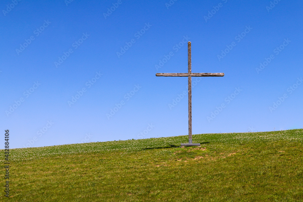 large wooden christian symbol cross standing on a grass hill or rural grassy hillside as a nature landscape religious background large wooden christian symbol cross standing on a grass hill or rural grassy hillside as a nature landscape religious background