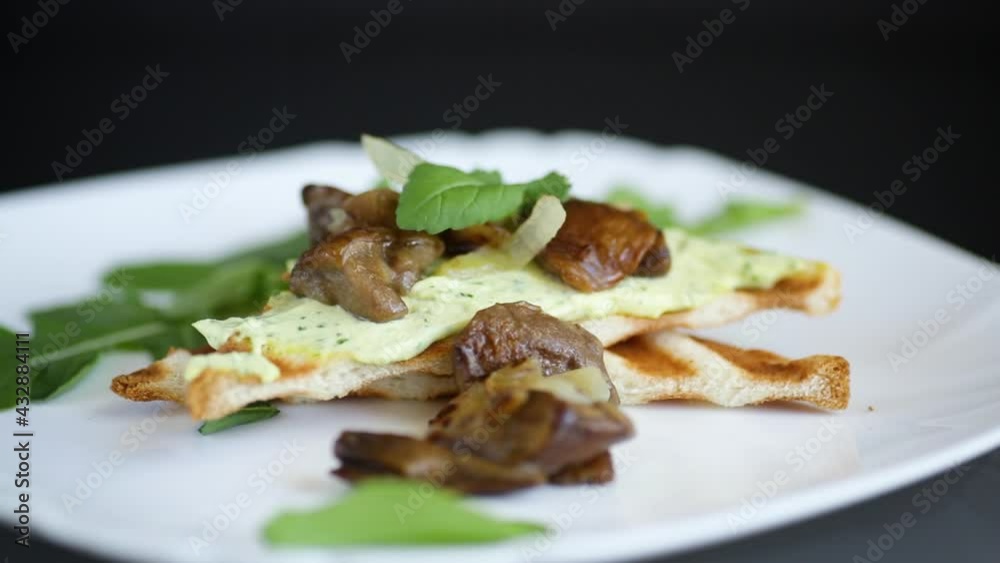 fried toast with cheese spread, arugula and fried mushrooms isolated on black background fried toast with cheese spread, arugula and fried mushrooms isolated on black background