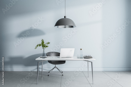 Cold shades interior design of home office workspace with black lamp from top, modern laptop on white marble tabletop and ceramic tales floor