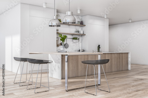 Sunny stylish spacious kitchen room with wooden furniture, black bar chairs and kitchen utensils and dishes on light wall.