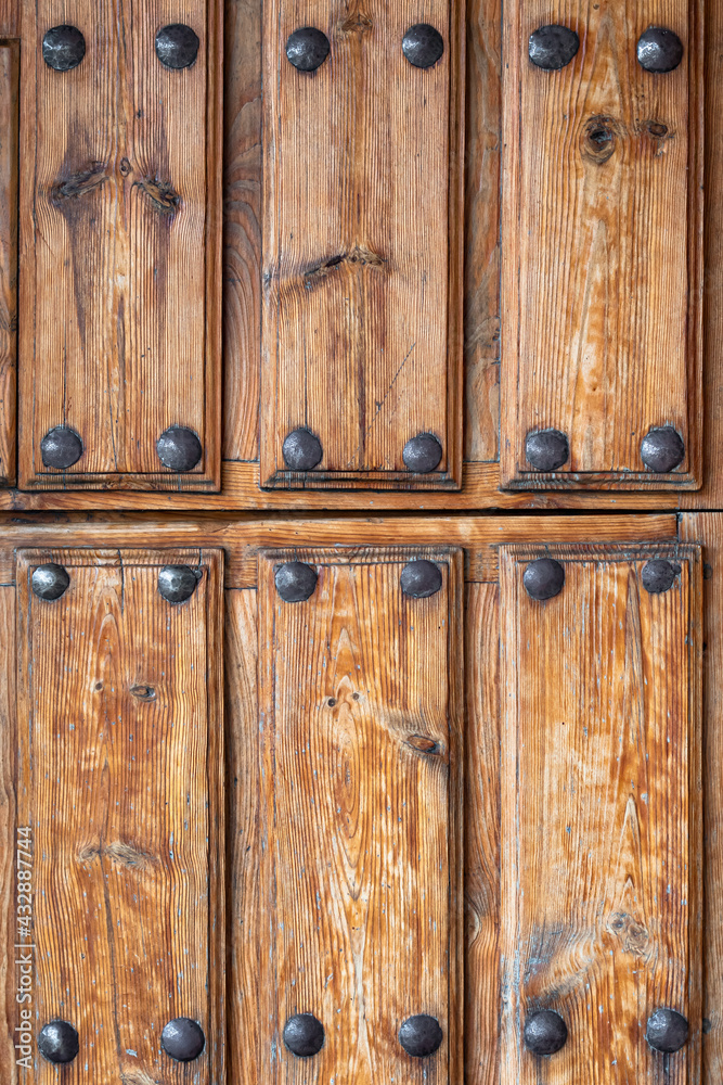 Antique wooden door with nails and knots. Rustic and retro old door full of knots and scratches. Vintage wood texture surface, wood vein. Pareidolia, faces in wood grain. Antique wooden door with nails and knots. Rustic and retro old door full of knots and scratches. Vintage wood texture surface, wood vein. Pareidolia, faces in wood grain.