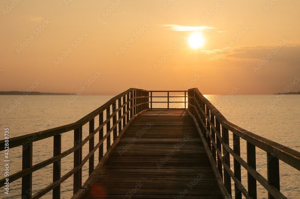 Romantic seascape with wooden walkway in golden light