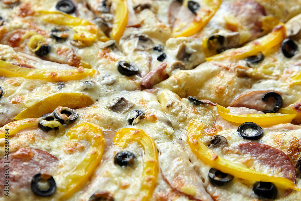 Pizza with chesse, ham, yellow bell pepper, olives and mushrooms closeup Pizza with chesse, ham, yellow bell pepper, olives and mushrooms closeup