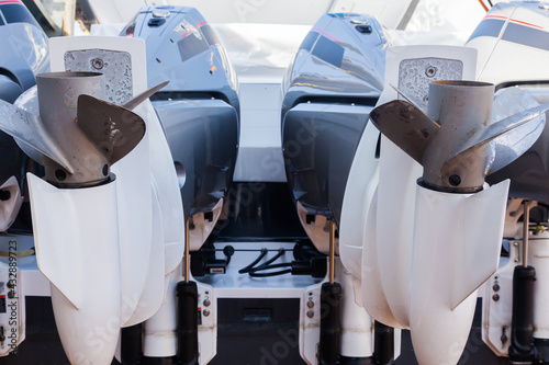 Motor propellers for motor yachts and boats close-up. The motors are installed at the stern of the boat. The outboard motors at the stern of the boat are raised. photo