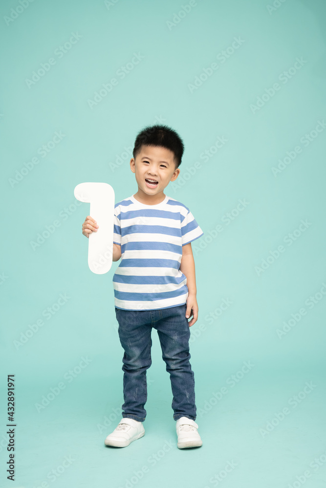 Asian boy smiling and showing number 1 isolated on green background, Full length people composition Asian boy smiling and showing number 1 isolated on green background, Full length people composition